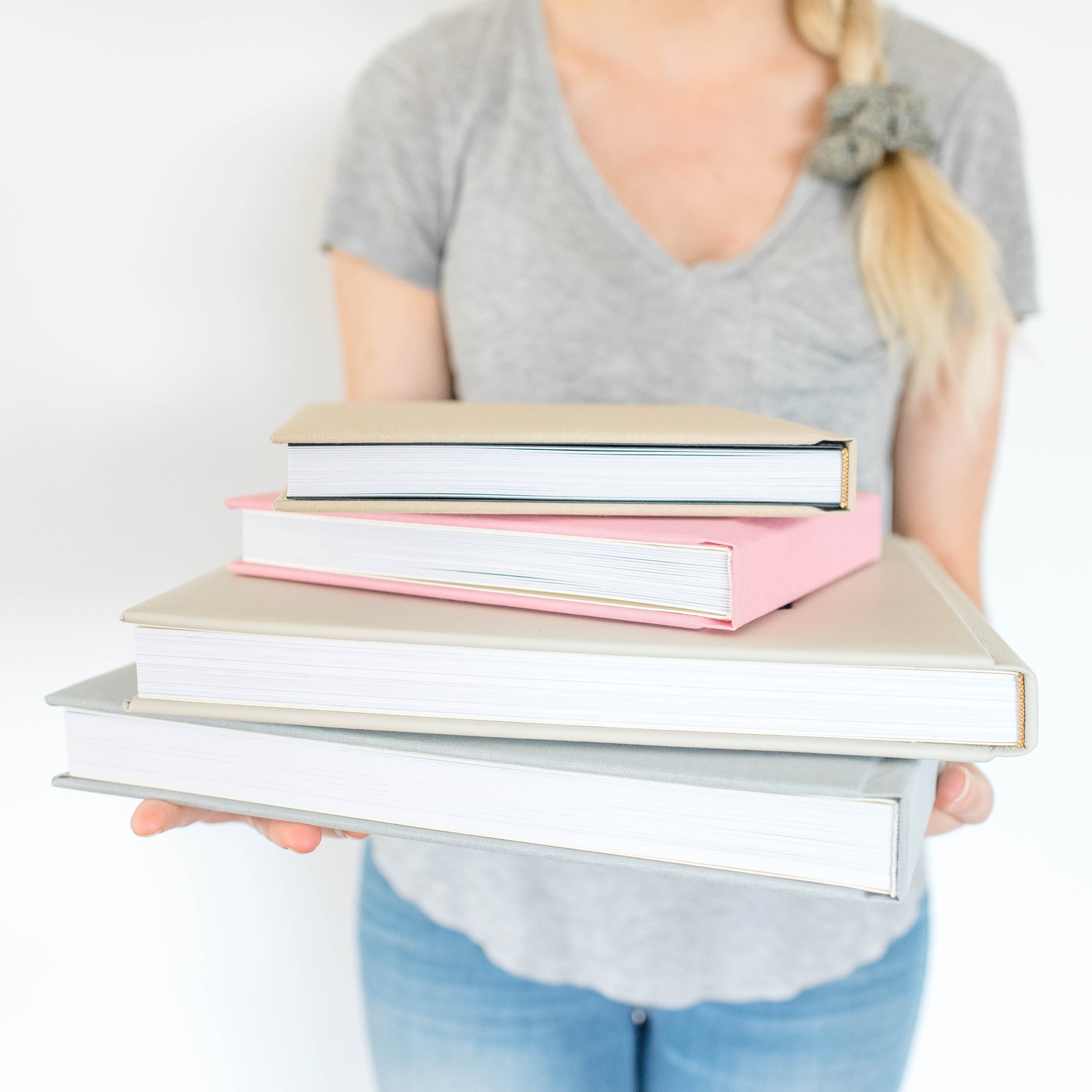 Frau hält Stapel mit Luxus Fotobüchern