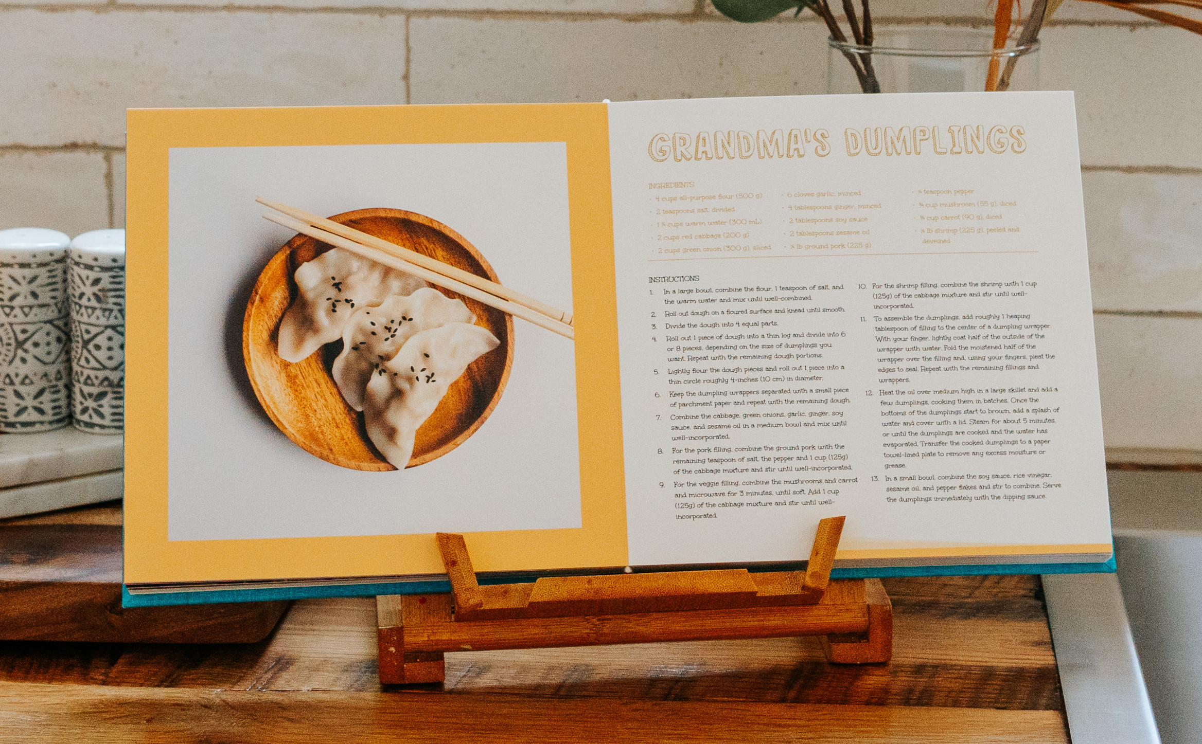 Custom cookbook standing on kitchen counter with dumpling recipe