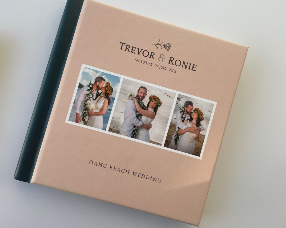 Wedding photo book with custom cover design for Trevor and Ronie’s Oahu beach wedding, featuring a peach background, three-photo layout, and color-block spine.
