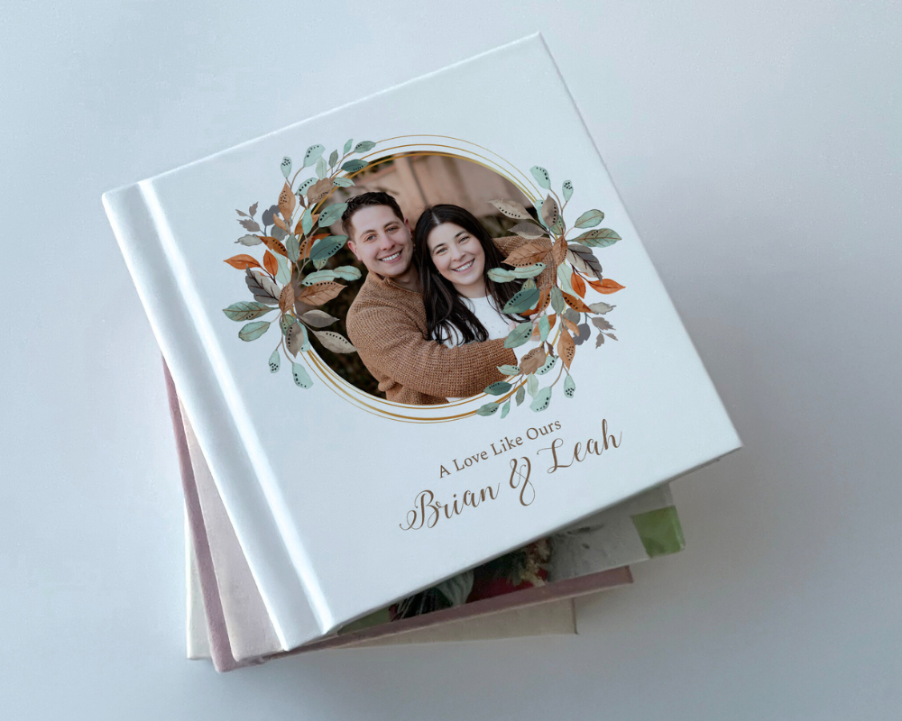 Custom wedding photo book with full photo cover, including autumn-themed floral graphic and personalized text, “A Love Like Ours – Brian & Leah.”