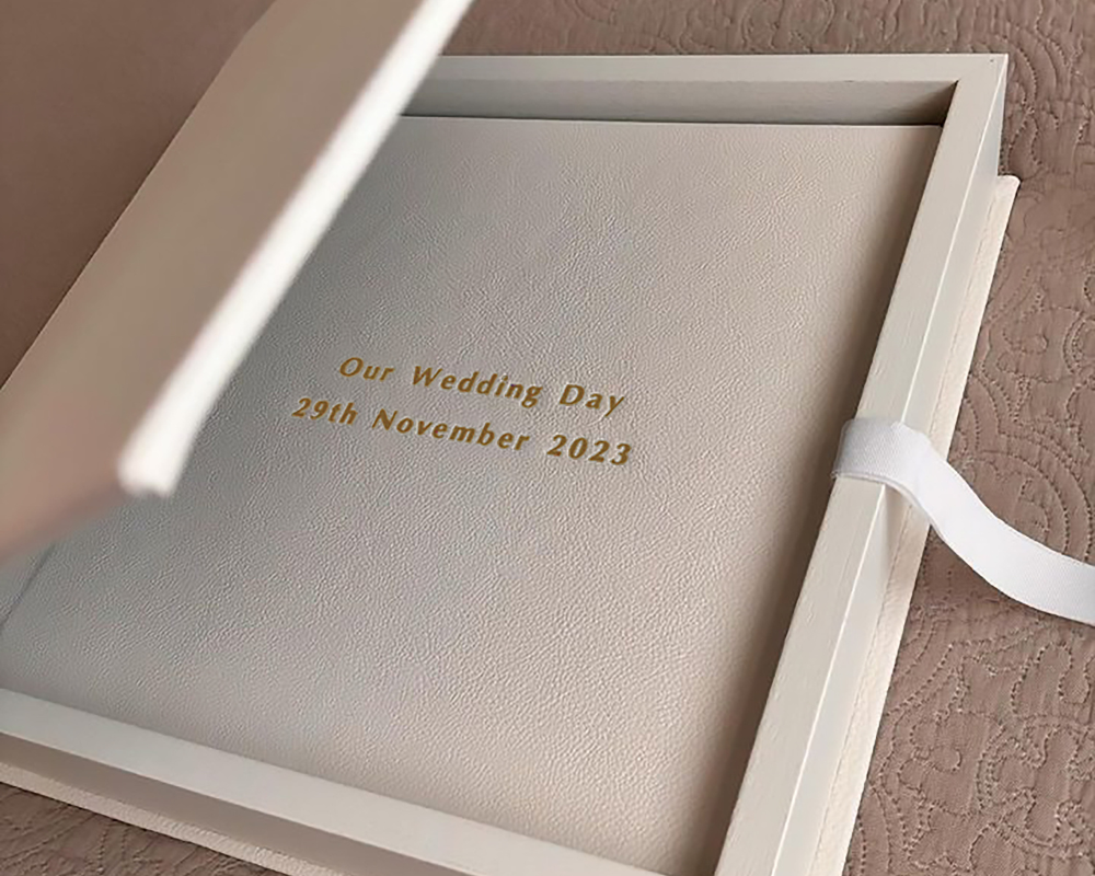 Elegant white leather photo book for wedding memories with gold embossed text and a matching vegan leather presentation box - designed to protect and preserve your most meaningful moments