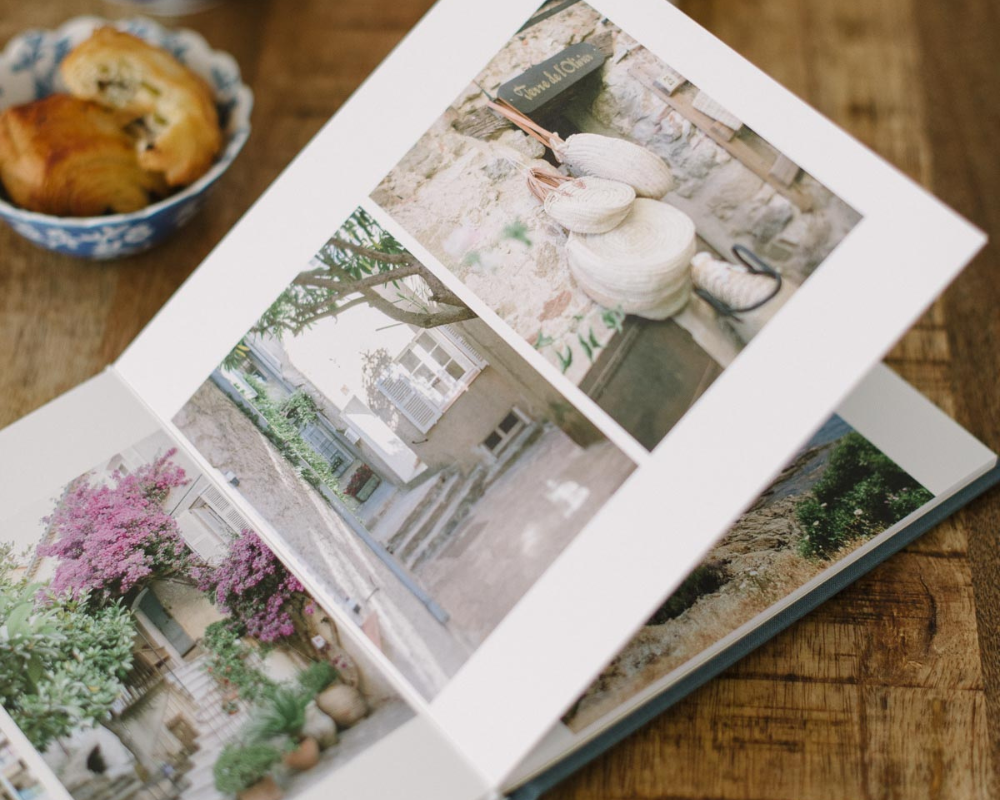 Open wedding photo album showing curated images of decor and other details arranged in a clean, elegant layout