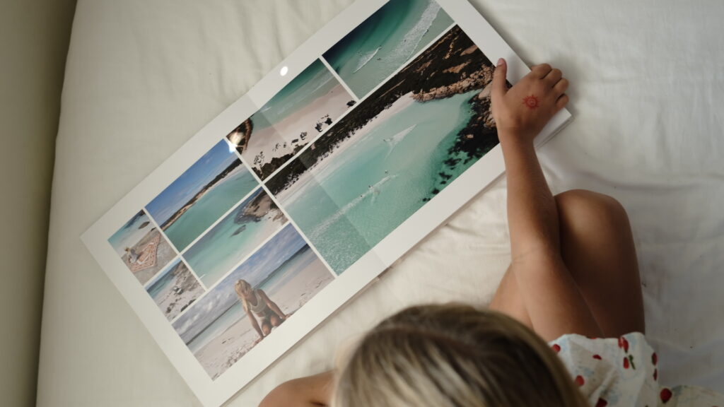 Open travel photo book with minimalist layout showing beach and turquoise ocean photography from Australia.