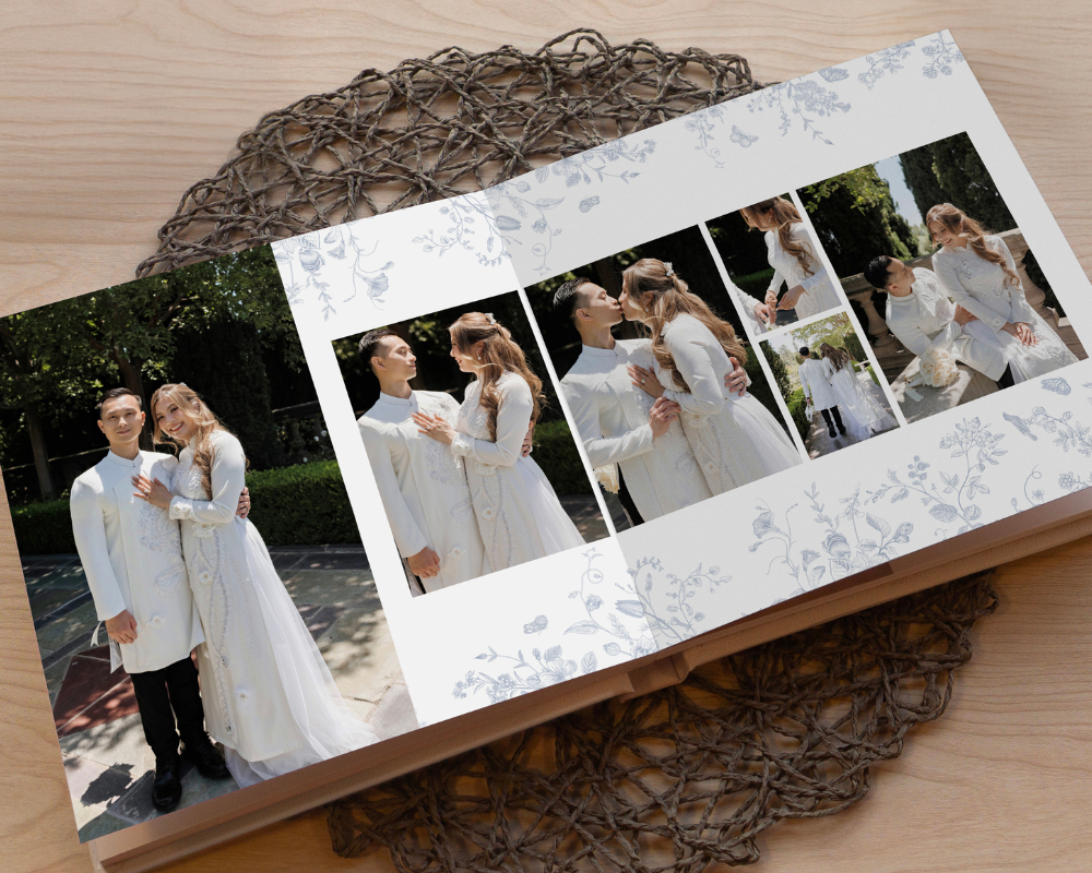 Premium layflat wedding album open to a romantic spread. The pages showcase a soft floral layout design, printed on thick, layflat Fuji Lustre paper.