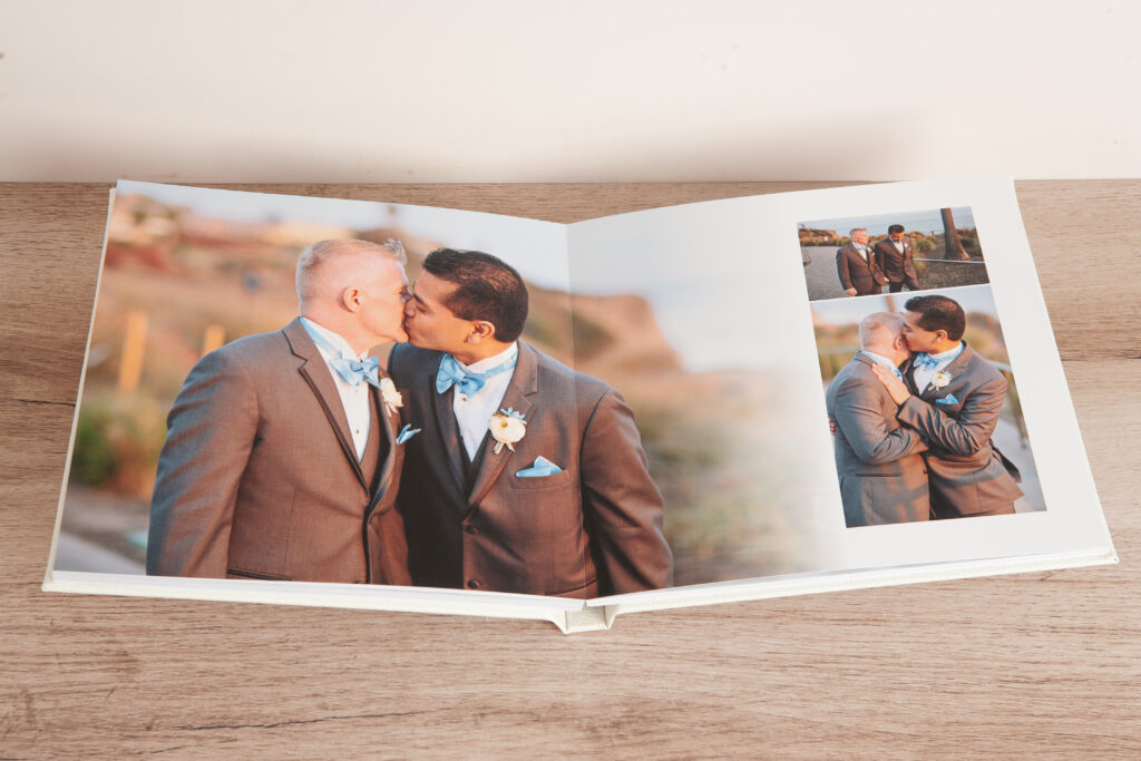 Layflat wedding album open showing couple's photo flowing seamlessly across both pages with no center crease interrupting the image