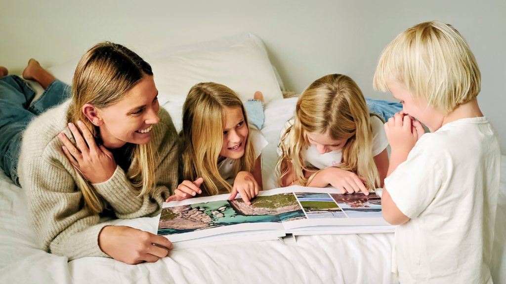 Brigita and her kids flip through a layflat travel photo book reminiscing over shared memories